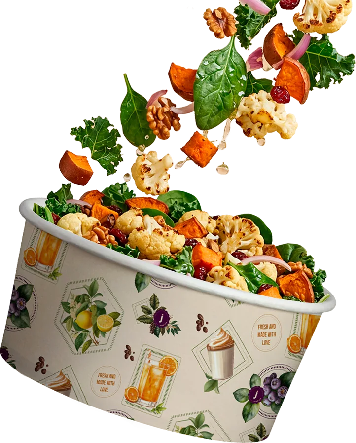 Bol de ensalada fresca con ingredientes cayendo